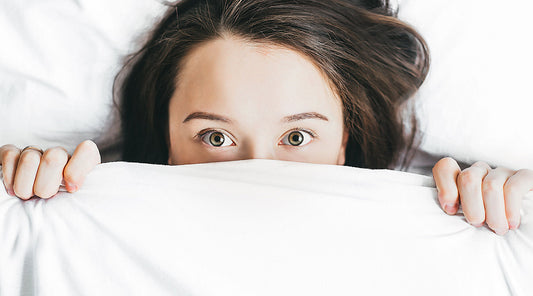 Woman covering face with blanket