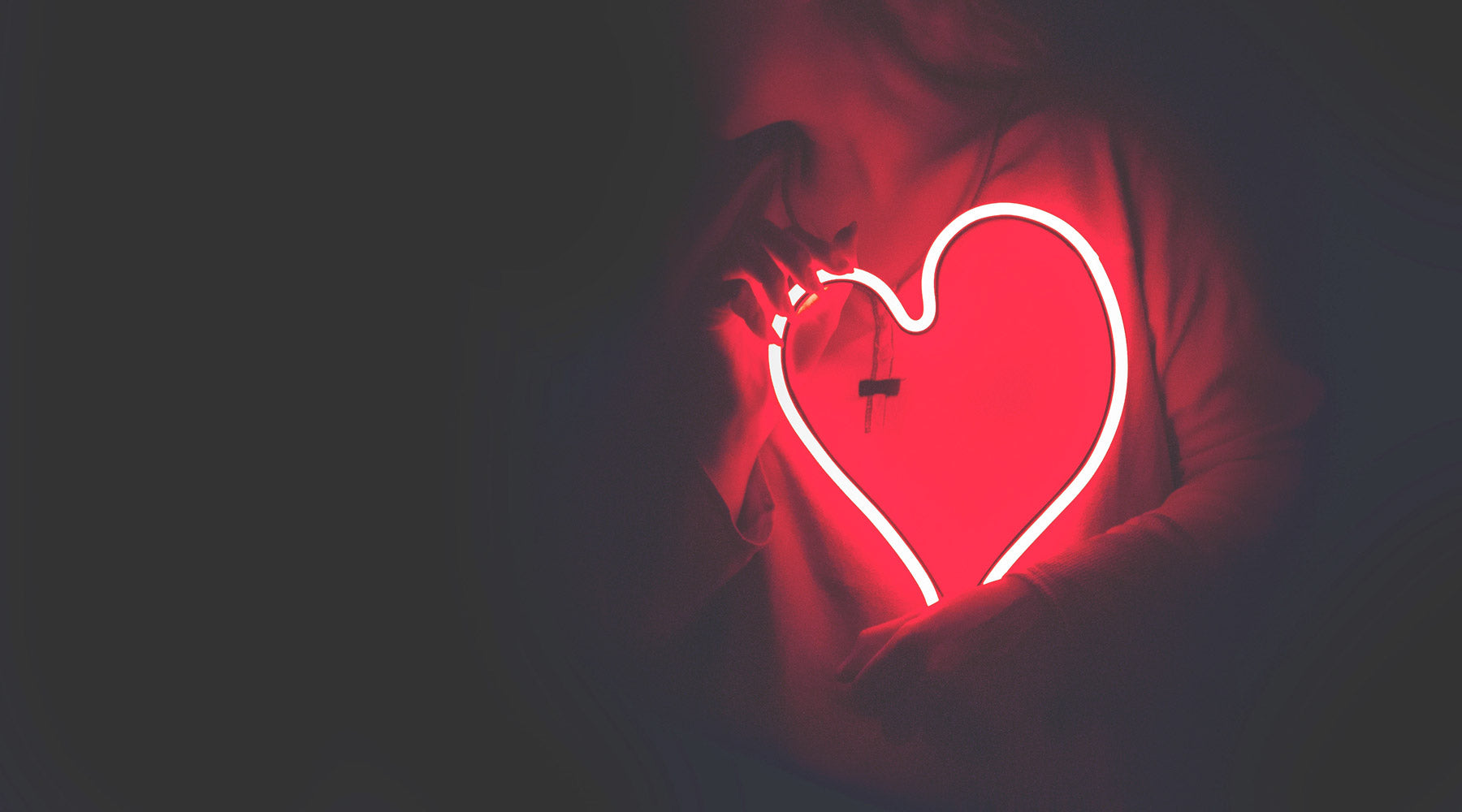 Person holding a neon heart