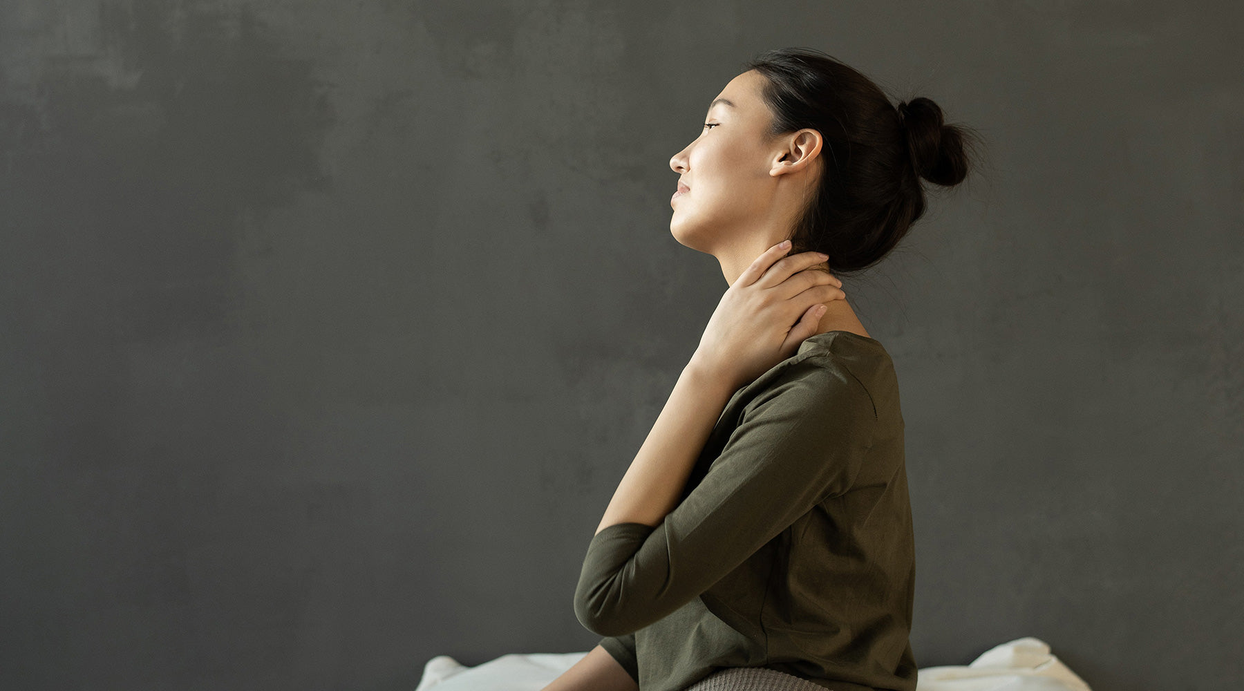 Woman sitting and massaging neck pain
