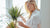 Woman with plant by the window